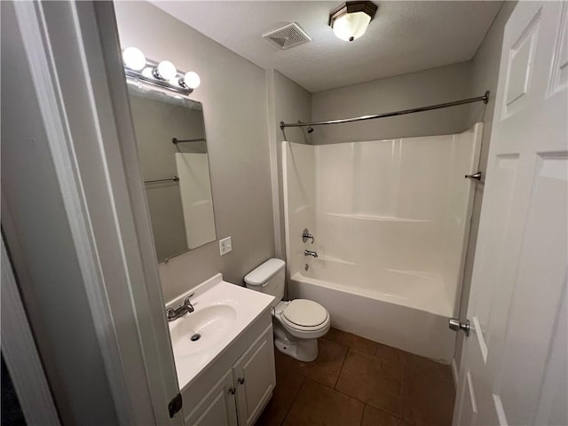 full bathroom with toilet, tile patterned floors, washtub / shower combination, vanity, and a textured ceiling