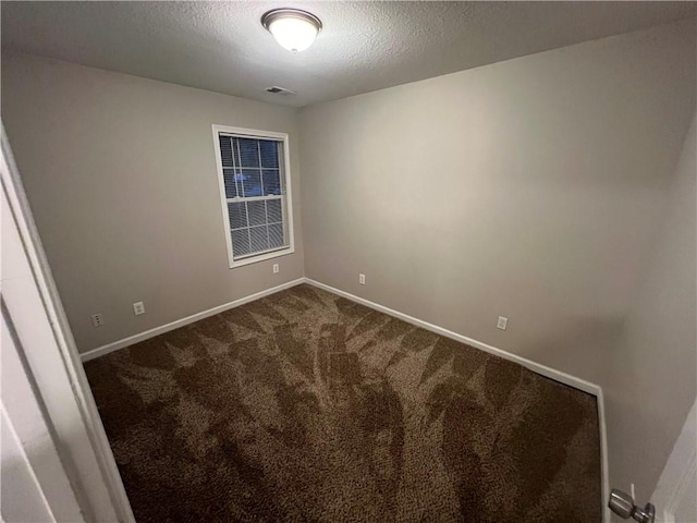 carpeted spare room with a textured ceiling