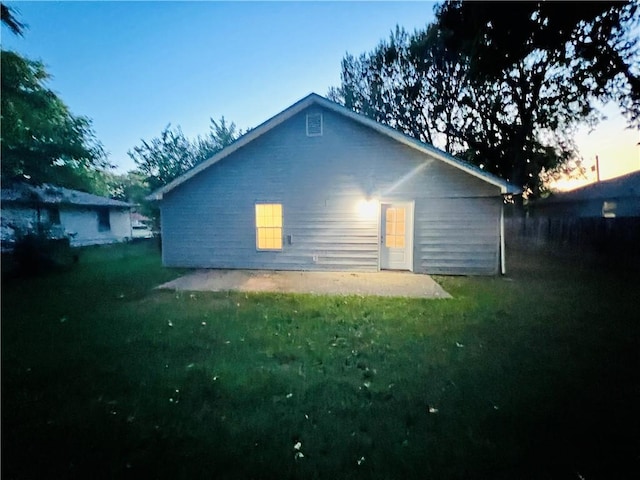 back house at dusk with a yard