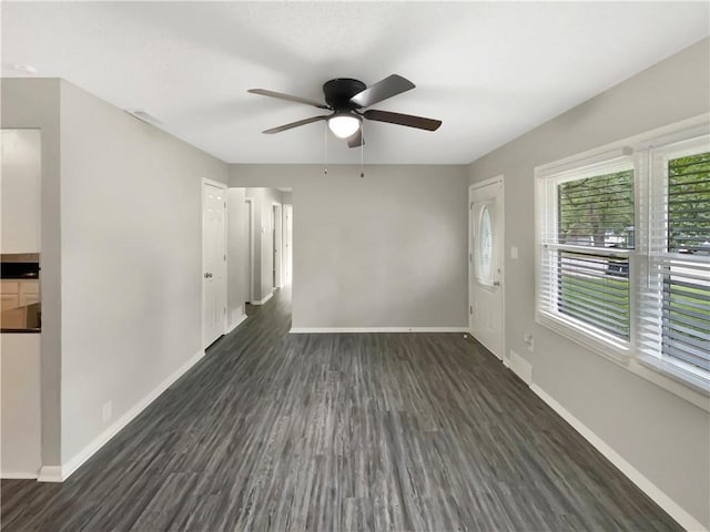 empty room with ceiling fan and dark hardwood / wood-style flooring