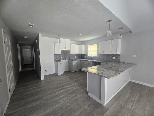 kitchen featuring pendant lighting, white cabinetry, decorative backsplash, kitchen peninsula, and dark wood-type flooring