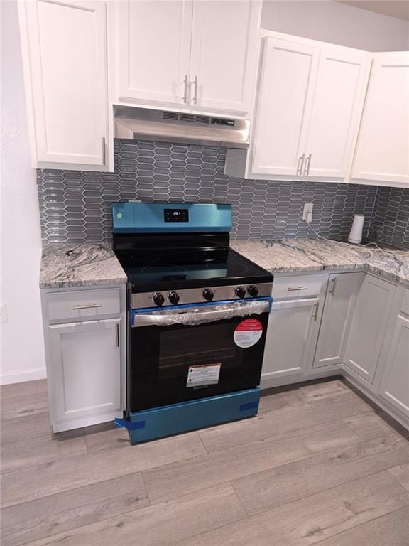 kitchen with stainless steel range with electric stovetop, tasteful backsplash, light hardwood / wood-style floors, and white cabinets