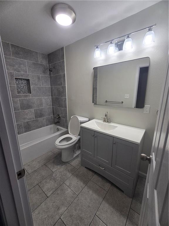 full bathroom with tiled shower / bath combo, vanity, tile patterned floors, and toilet