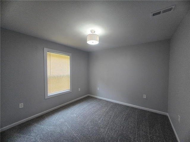 unfurnished room with dark carpet