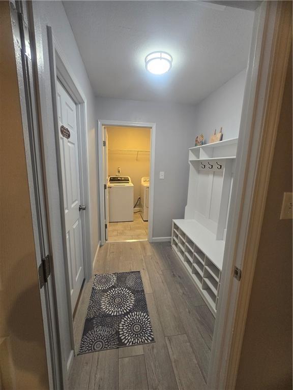 mudroom with washing machine and dryer and light hardwood / wood-style flooring