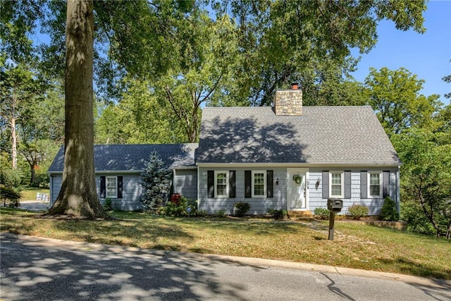 cape cod house featuring a front yard