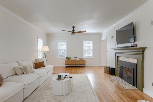 living room with ornamental molding, plenty of natural light, and light hardwood / wood-style flooring