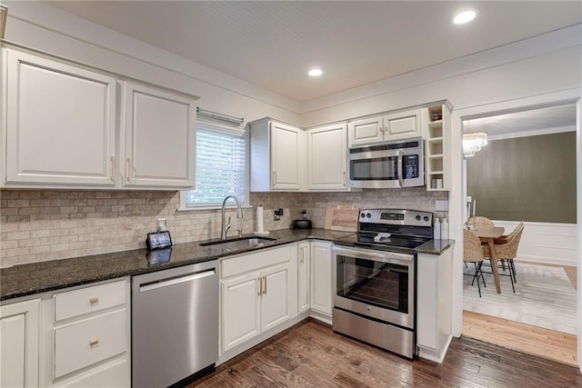 kitchen featuring sink, dark stone countertops, dark hardwood / wood-style flooring, stainless steel appliances, and white cabinets