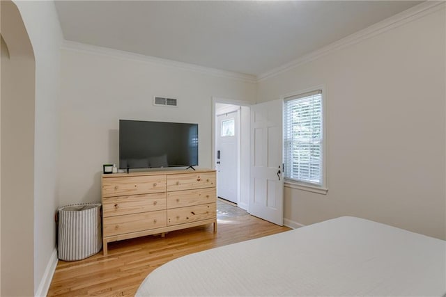 bedroom with crown molding and light hardwood / wood-style flooring