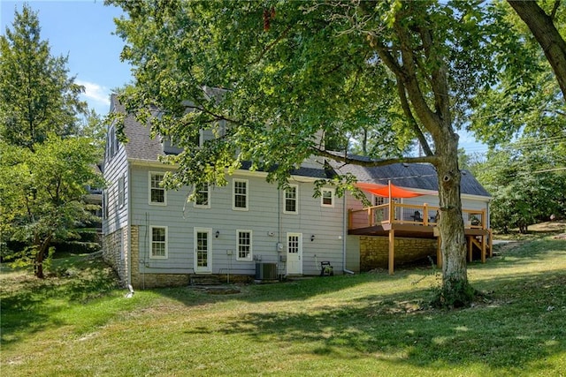 back of property featuring a wooden deck and a yard