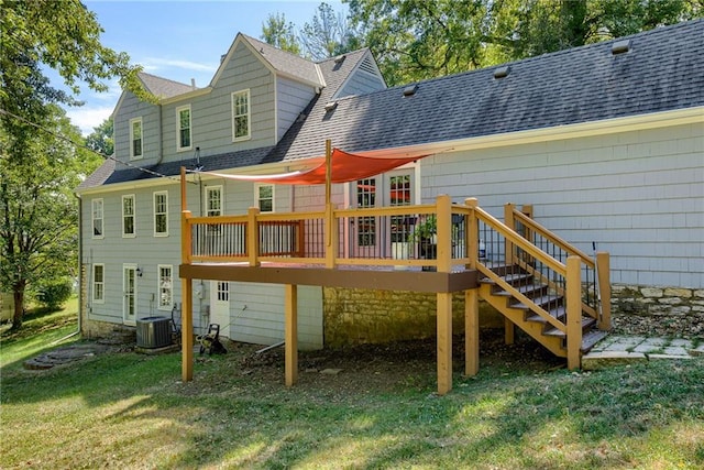 rear view of house with central AC unit, a deck, and a lawn