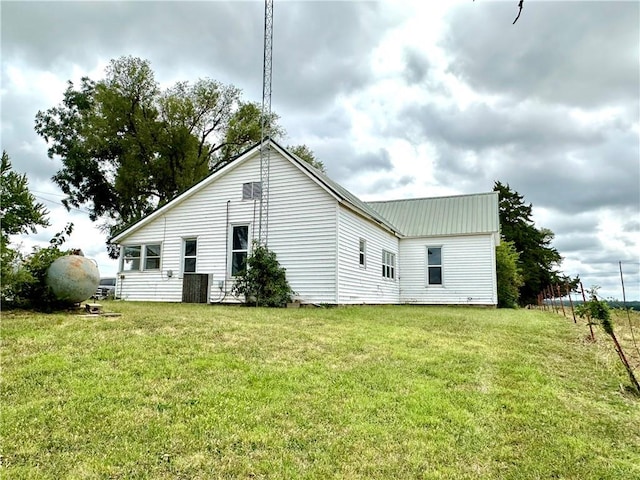 rear view of house featuring a yard