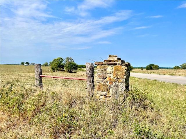 community / neighborhood sign with a rural view