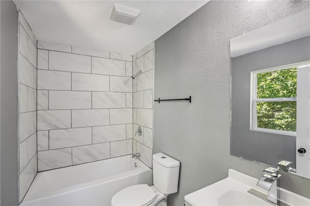 full bathroom with vanity, tiled shower / bath, and toilet