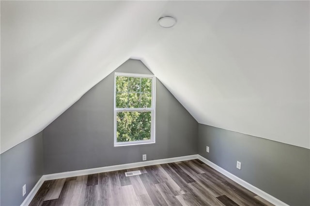 bonus room with lofted ceiling and dark hardwood / wood-style floors