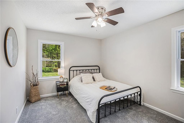 carpeted bedroom with a textured ceiling and ceiling fan