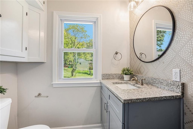 bathroom featuring a wealth of natural light, vanity, and toilet