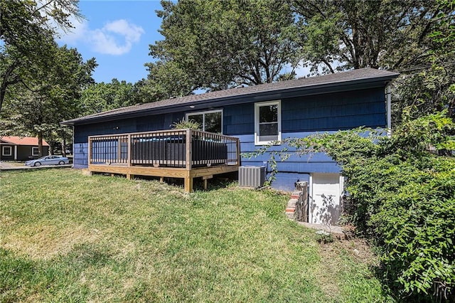 rear view of property with a deck, a lawn, and cooling unit