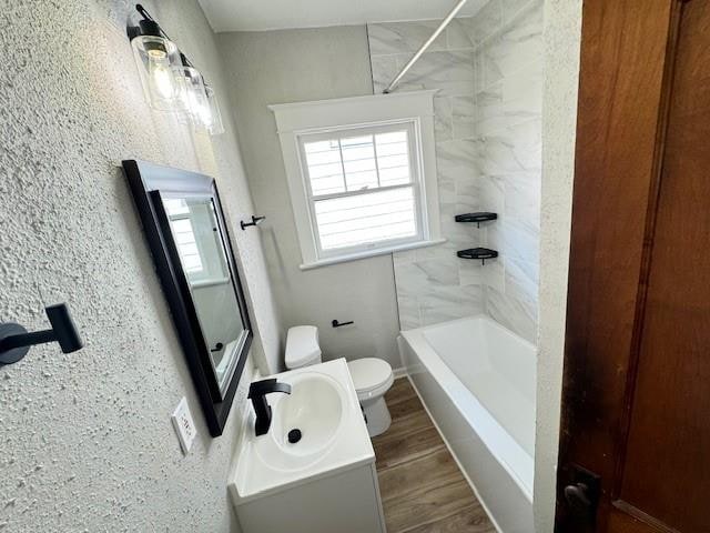 full bathroom with vanity, toilet, tiled shower / bath combo, and wood-type flooring