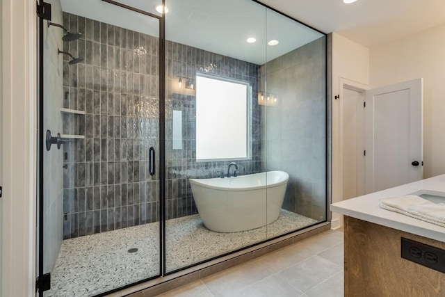 bathroom with tile patterned flooring, shower with separate bathtub, and vanity