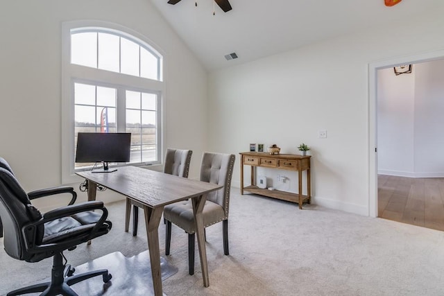 carpeted home office with high vaulted ceiling and ceiling fan