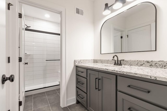 bathroom featuring tile patterned flooring, vanity, and a shower with door