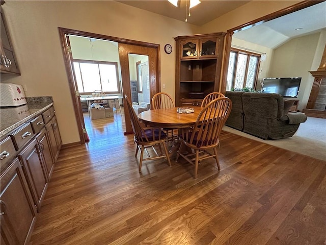 dining area with lofted ceiling, dark wood-type flooring, ceiling fan, and a healthy amount of sunlight