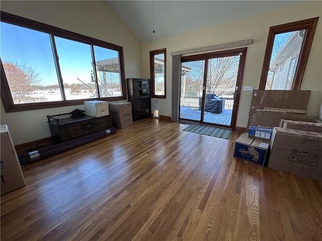 unfurnished living room with lofted ceiling, dark wood-type flooring, and plenty of natural light