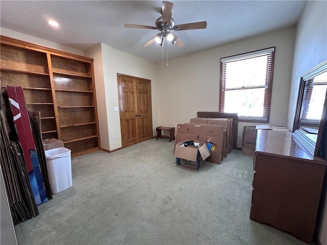 sitting room featuring a textured ceiling, ceiling fan, and light carpet