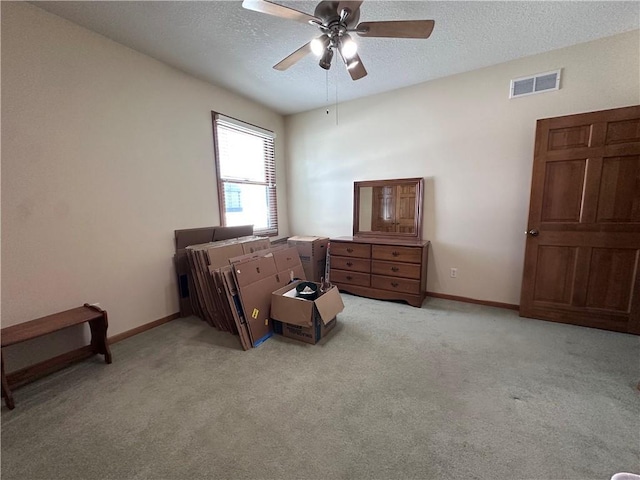 carpeted bedroom with a textured ceiling and ceiling fan