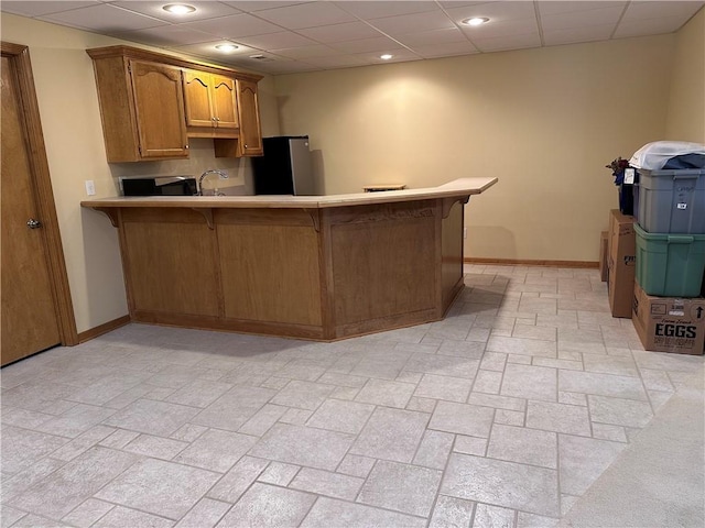 kitchen with stainless steel appliances, a kitchen breakfast bar, sink, and kitchen peninsula