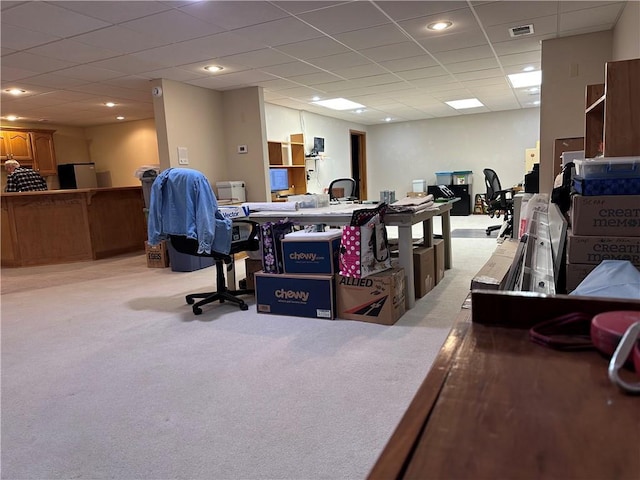 carpeted office with a drop ceiling