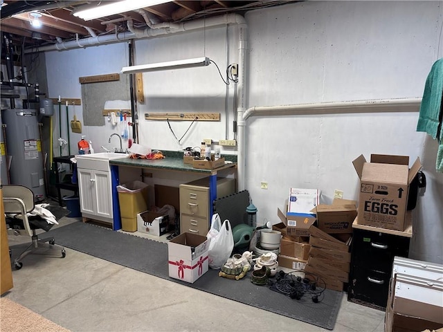 basement with sink, a workshop area, and water heater