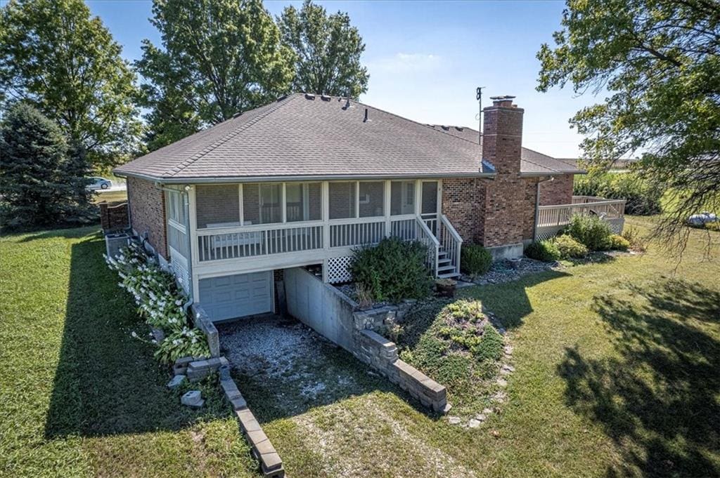 rear view of house with a garage and a yard