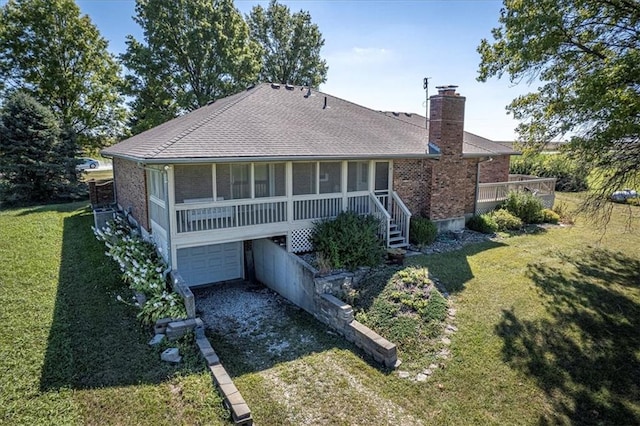 rear view of house with a garage and a yard