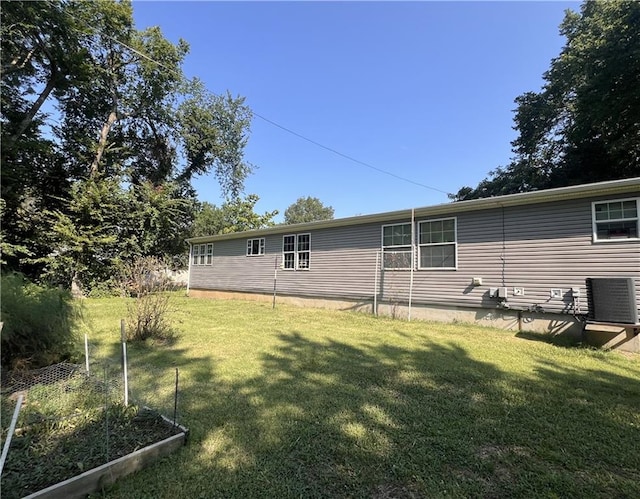 rear view of house featuring a yard and central AC