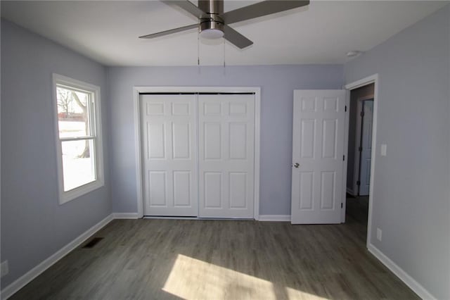 unfurnished bedroom featuring dark wood-type flooring, ceiling fan, and a closet