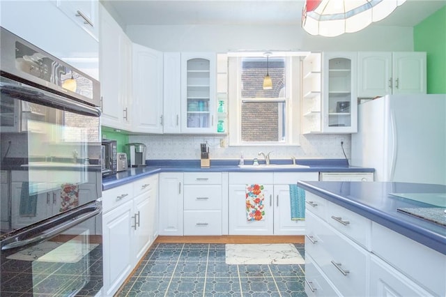 kitchen featuring white fridge, tasteful backsplash, decorative light fixtures, sink, and double oven