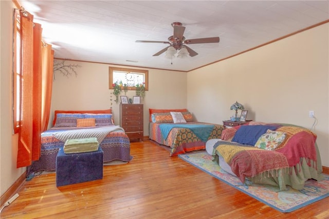 bedroom with ceiling fan, hardwood / wood-style flooring, and crown molding