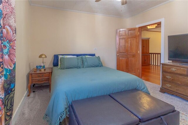 carpeted bedroom featuring ceiling fan and ornamental molding