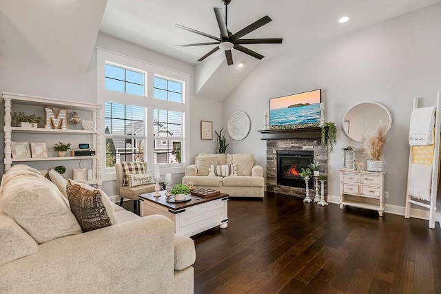 living room featuring high vaulted ceiling, ceiling fan, dark hardwood / wood-style floors, and a stone fireplace