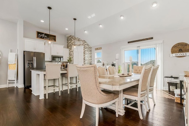 dining room with dark hardwood / wood-style flooring and vaulted ceiling