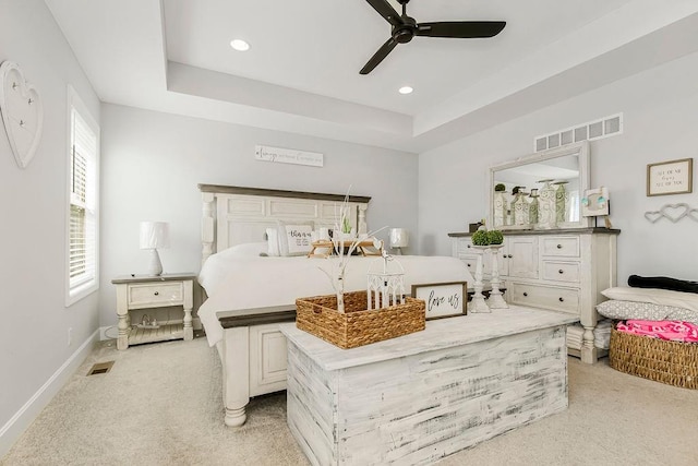 bedroom featuring a tray ceiling, ceiling fan, and light colored carpet