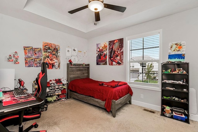 bedroom featuring a tray ceiling, ceiling fan, and carpet