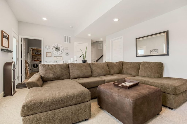 carpeted living room featuring washer / dryer