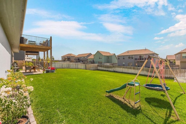 view of yard featuring a balcony, a playground, and a patio area