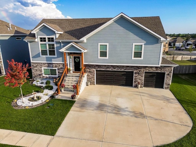 bi-level home featuring a garage and a front lawn