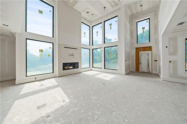 unfurnished living room featuring a high ceiling