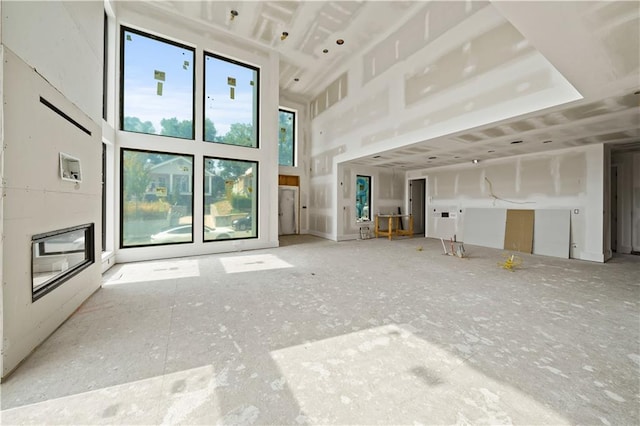 unfurnished living room with a towering ceiling