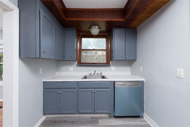 kitchen featuring light wood-type flooring, dishwasher, blue cabinetry, and sink